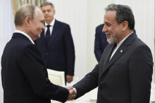 Ruský prezident Vladimir Putin a iránsky minister zahraničných vecí Abbás Arákčí si podávajú ruky pred spoločnými rozhovormi v Moskve. FOTO: TASR/AP