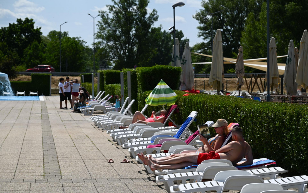 Návštevníci sa opaľujú pri bazénoch počas otvorenia letného kúpaliska v Trenčíne. FOTO: TASR/Martin Medňanský