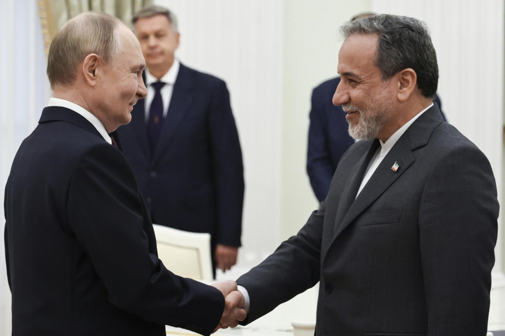 Ruský prezident Vladimir Putin a iránsky minister zahraničných vecí Abbás Arákčí si podávajú ruky pred spoločnými rozhovormi v Moskve. FOTO: TASR/AP