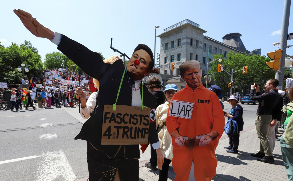 Demonštranti držia podobizne Elona Muska a Donalda Trumpa počas protestu, ktorý sa 14. júna konal v Ottawe pred kanadským summitom G7. FOTO: Reuters