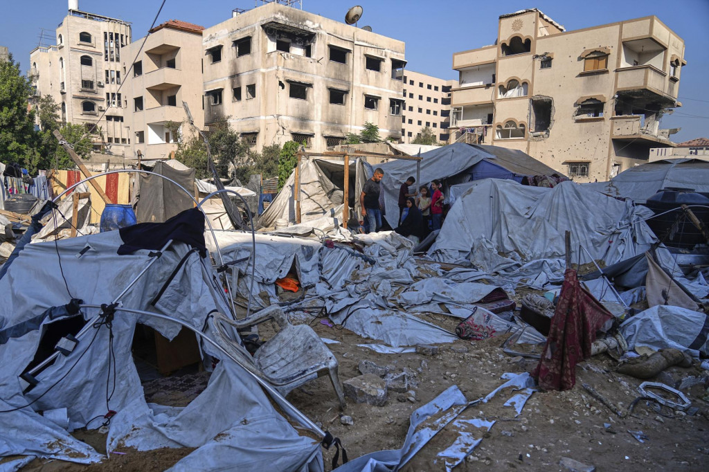 Palestínčania prehľadávajú zničené stany po izraelskom leteckom útoku na stanovú osadu, kde sa nachádzali vojnoví utečenci v centre mesta Gaza. FOTO: TASR/AP