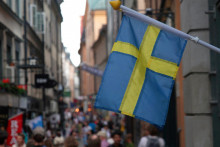 FILE PHOTO: A Swedish flag hangs outside a store on a busy street as visitors walk past in the background in the old town of Stockholm, Sweden, July 14, 2023 REUTERS/Tom Little/File Photo FOTO: TOM LITTLE