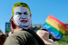 Účastník pochodu s maskou Viktora Orbána. FOTO: REUTERS
