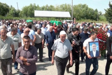 Ľudia nasledovaní smútiacimi nesú rakvy azerbajdžanských bratov Huseyna a Zijaddina Safarovcov, ktorí zomreli po zatknutí ruskou políciou. FOTO: Reuters