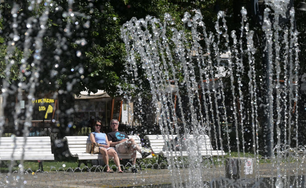 Ľudia počas horúceho letného dňa pri spievajúcej fontáne v parku na Hlavnej ulici v Košiciach. FOTO: TASR/František Iván
