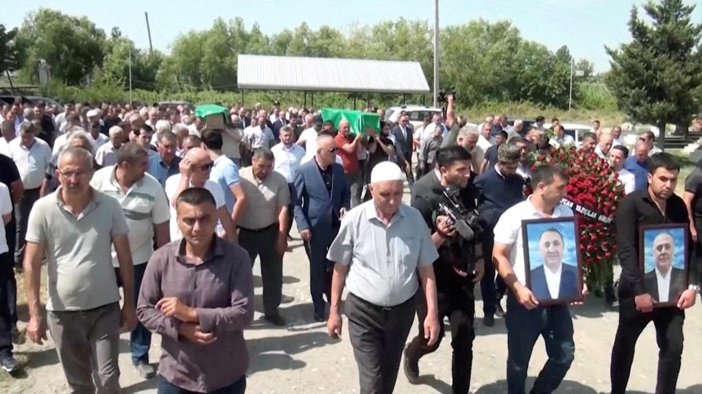 Ľudia nasledovaní smútiacimi nesú rakvy azerbajdžanských bratov Huseyna a Zijaddina Safarovcov, ktorí zomreli po zatknutí ruskou políciou. FOTO: Reuters