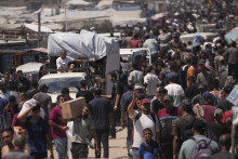 Palestínčania nesú vrecia s potravinami a balíčkami humanitárnej pomoci v meste Rafah na juhu Pásma Gazy. FOTO: TASR/AP