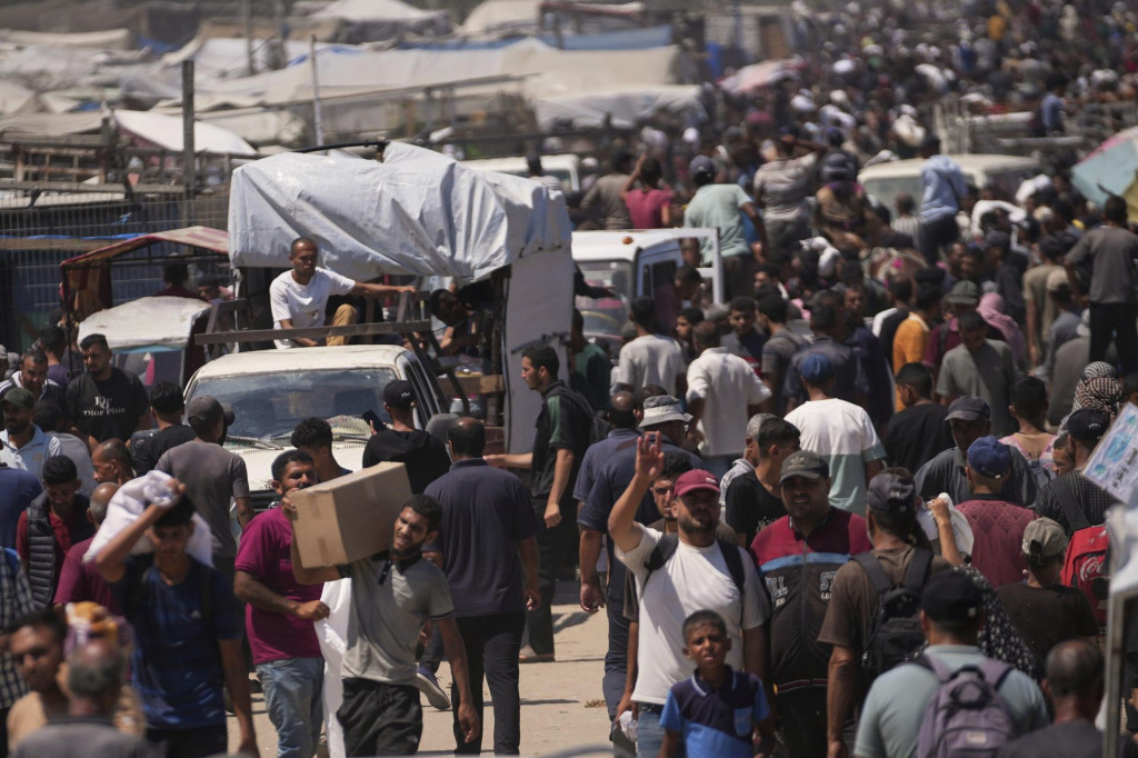 Palestínčania nesú vrecia s potravinami a balíčkami humanitárnej pomoci v meste Rafah na juhu Pásma Gazy. FOTO: TASR/AP