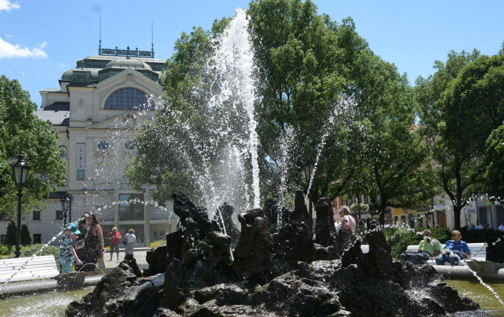 Ľudia počas horúceho letného dňa pri fontáne znamení v parku na Hlavnej ulici v Košiciach. FOTO: TASR/František Iván