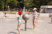 Deti si užívajú horúci letný deň vo fontáne Družba na Námestí slobody v Bratislave. FOTO: TASR/Miroslav Košírer