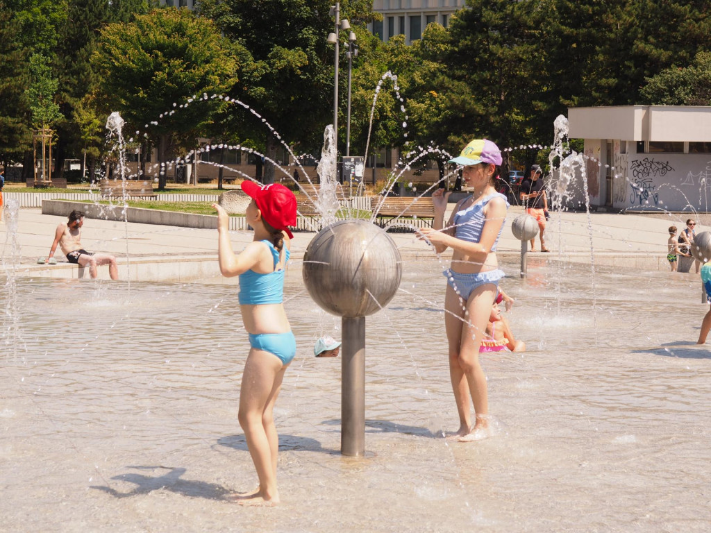 Deti si užívajú horúci letný deň vo fontáne Družba na Námestí slobody v Bratislave. FOTO: TASR/Miroslav Košírer