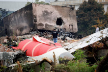 Hasič stojí vedľa havarovaného lietadla Boeing 787-8 Dreamliner spoločnosti Air India v Ahmadábáde v Indii. FOTO: Reuters