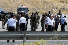 Kurdské bezpečnostné sily a ďalší vojaci stoja na kontrolnom stanovišti v deň slávnostného odzbrojenia bojovníkov Strany kurdských pracujúcich. FOTO: Reuters