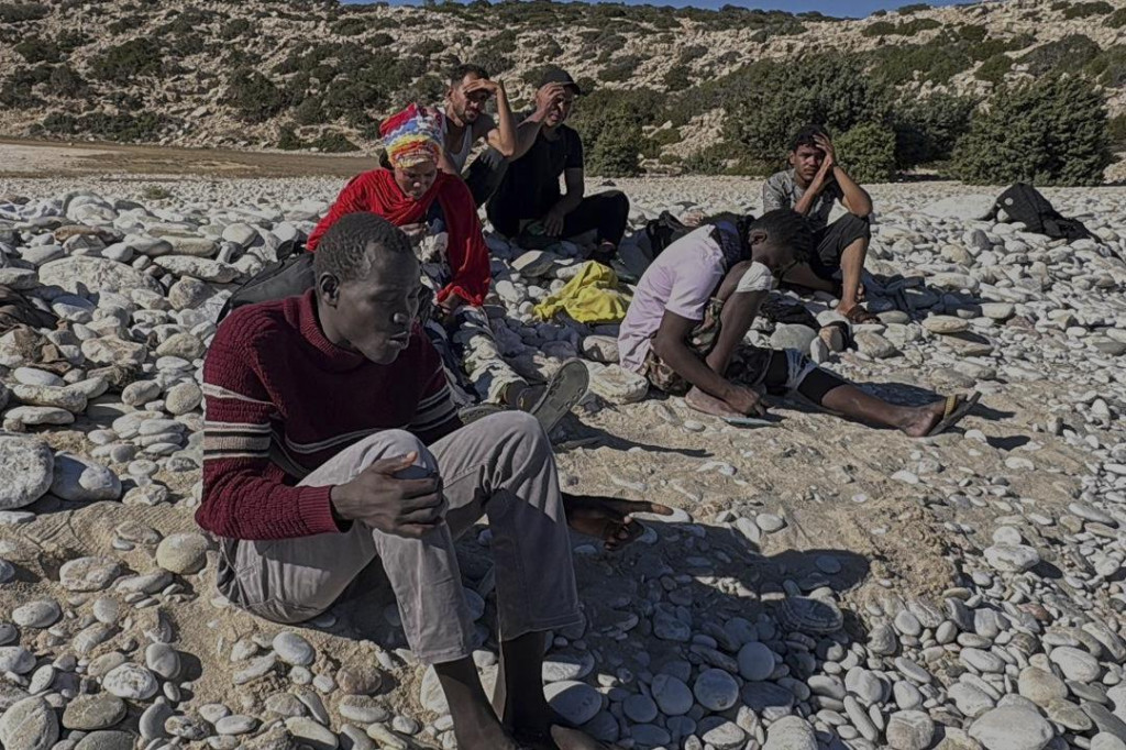 David, migrant z Južného Sudánu, sedí na pláži Tripiti spolu s ďalšími piatimi osobami zo skupiny 68 migrantov a utečencov, ktorí prišli na najjužnejší grécky ostrov Gavdos. FOTO: TASR/AP