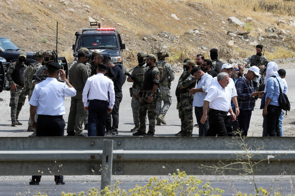 Kurdské bezpečnostné sily a ďalší vojaci stoja na kontrolnom stanovišti v deň slávnostného odzbrojenia bojovníkov Strany kurdských pracujúcich. FOTO: Reuters