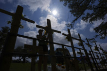 Lara Merrittová kladie kvety k provizórnemu pamätníku obetiam povodní, ktorý bol postavený na brehu rieky Guadalupe v meste Kerrville v americkom štáte Texas. FOTO: TASR/AP