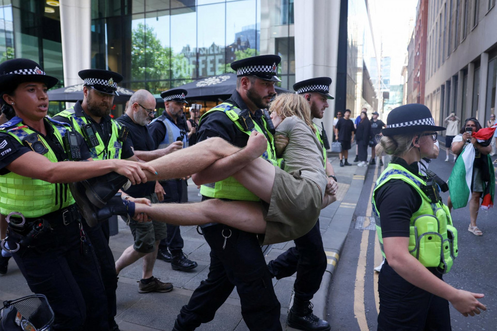 Policajti nesú zadržanú demonštrantku počas protestu požadujúceho zrušenie zákazu skupiny Palestíne Action v Manchestri v Spojenom kráľovstve. FOTO: Reuters