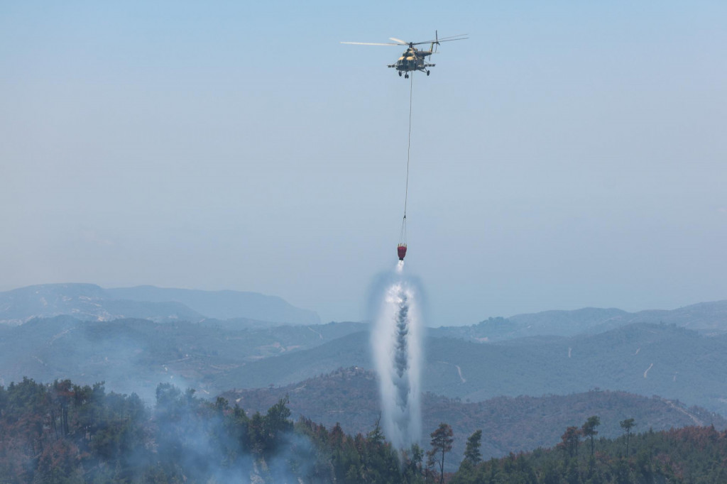Sýrska helikoptéra zhadzuje vodu počas lesného požiaru v meste Rabia v sýrskej provincii Lázikíja. FOTO: TASR/AP