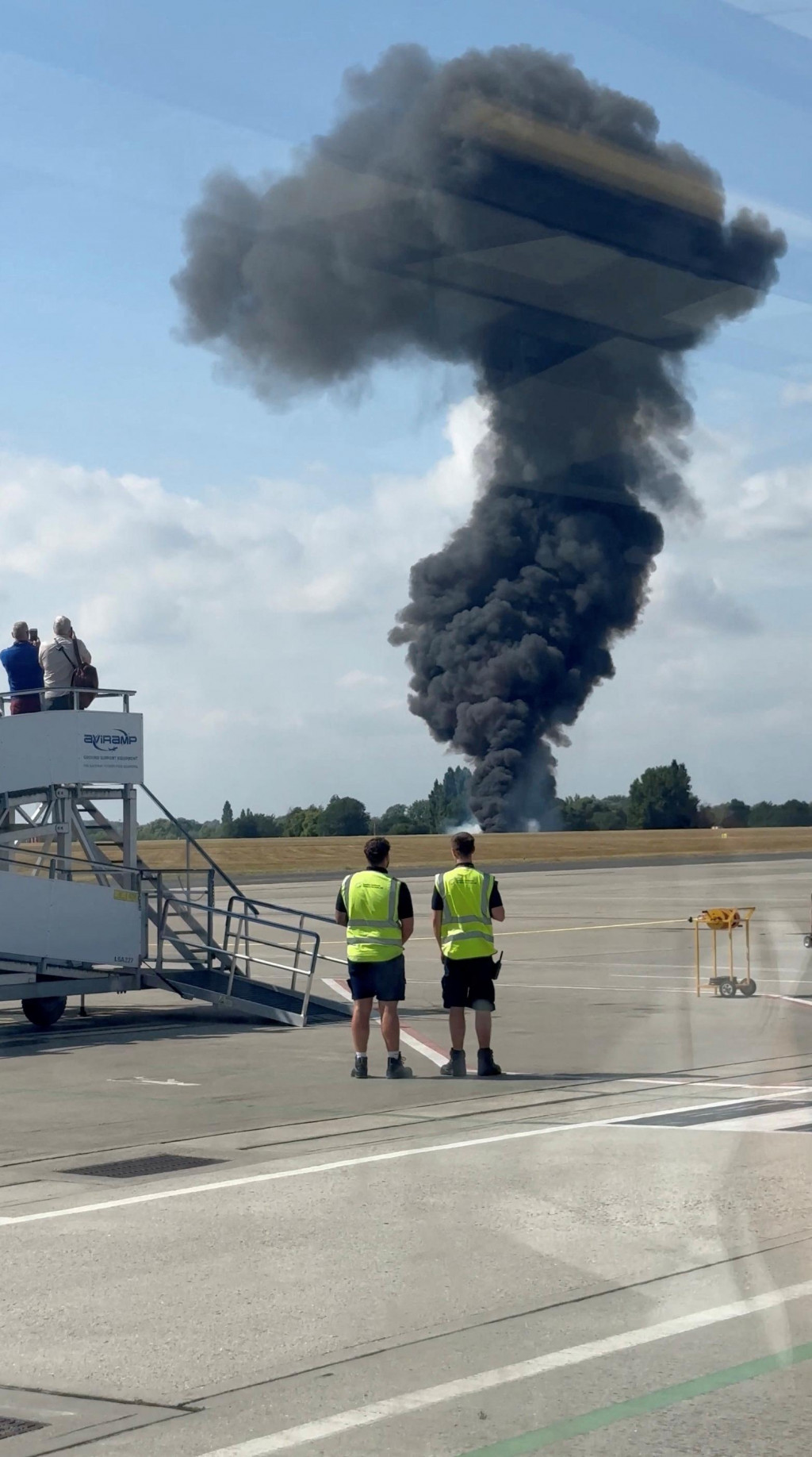 Stĺp čierneho dymu stúpa z oblasti blízko pristávacej dráhy po havárii malého lietadla na letisku London Southend. FOTO: Reuters