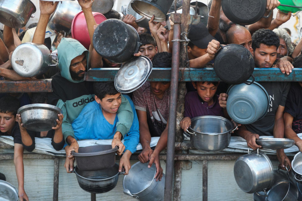 Palestínčania čakajú na jedlo. FOTO: Reuters