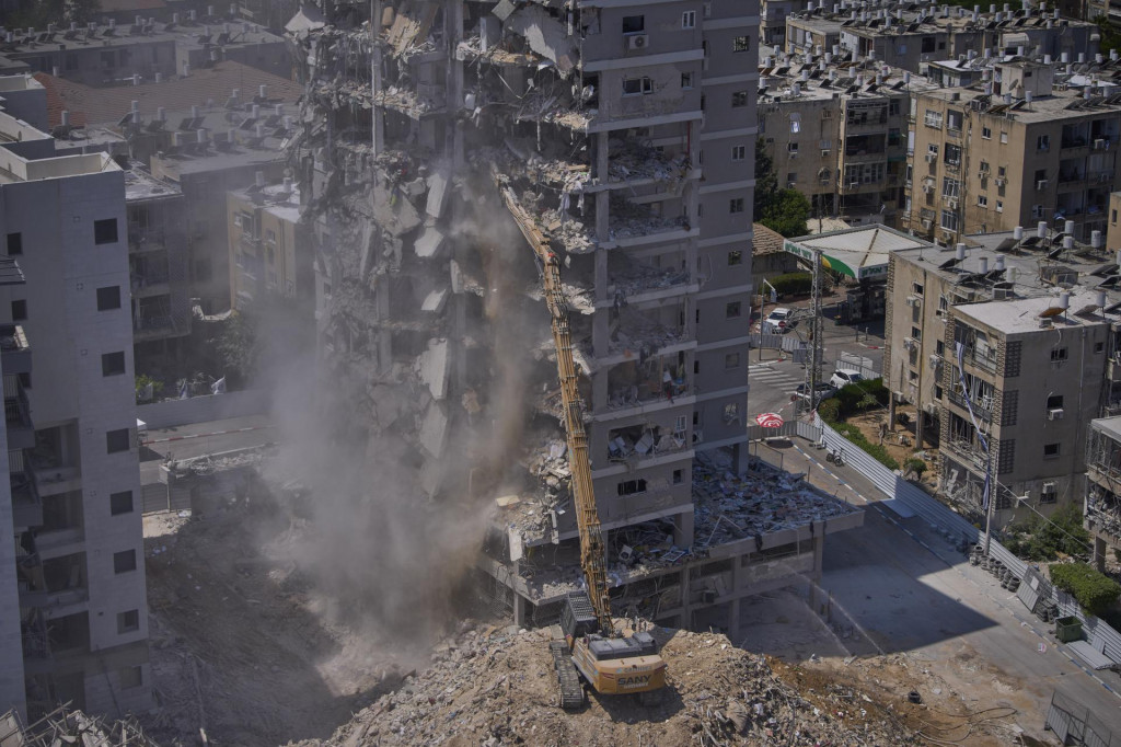Obytná budova zničená po iránskom raketovom útoku počas minulomesačnej 12-dňovej vojny Izraela s Iránom, je demolovaná v izraelskom meste Bat Jam. FOTO: TASR/AP