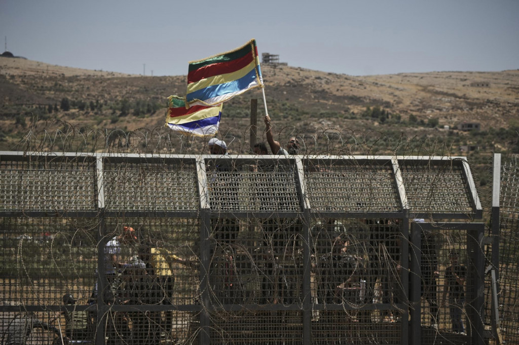 Sýrski drúzovia protestujú neďaleko izraelsko-sýrskej hranice, čo je vidieť z mesta Majdal Šams, na území Izraelom okupovaných Golanských výšin. FOTO: TASR/AP