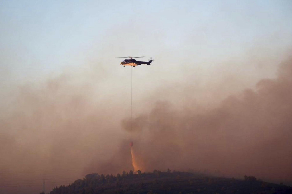 Vrtuľník počas hasenia lesného požiaru, ktorý vyčíňa v okolí mesta Martigues, neďaleko Marseille, na juhovýchode Francúzska. FOTO: TASR/AP