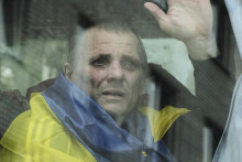 Ukrajinský vojak, ktorého prepustili zo zajatia, máva z okna autobusu po výmene vojnových zajatcov medzi Ruskom a Ukrajinou v Černihivskej oblasti na severe Ukrajiny pri hraniciiach s Ruskom a Bieloruskom v piatok 4. júla 2025. FOTO: TASR/AP