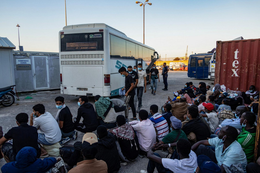 Novoprichádzajúci migranti čakajú na nástup do autobusu pred budovou mestského úradu v meste Agyia na ostrove Kréta v Grécku. FOTO: Reuters