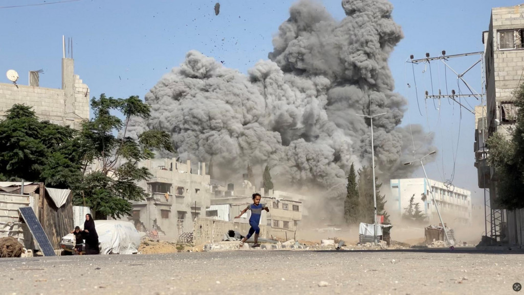 Dievča uteká z miesta činu po izraelských útokoch na školu, ktorá poskytuje útočisko vysídleným osobám v utečeneckom tábore Bureij v centrálnom pásme Gazy. FOTO: Reuters