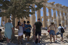 Snímka z 9. júla zachytáva turistov ukrývajúcich sa v tieni stromu na aténskej Akropole. Horúčavy sa v tom týždni šplhali k 40 stupňom Celzia. FOTO: TASR/AP