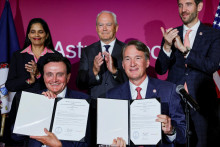 Generálny riaditeľ spoločnosti AstraZeneca Pascal Soriot a guvernér Virgínie Glenn Youngkin ukazujú dokumenty súvisiace s investíciou do výrobného závodu. FOTO: Reuters