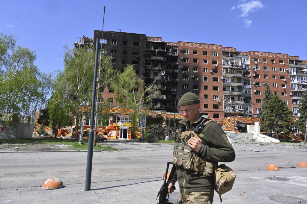 Na archívnej snímke z 23. apríla 2025 ukrajinský vojak prechádza okolo poškodených budov po útokoch ruskej armády v meste Pokrovsk v Doneckej oblasti na Ukrajine. FOTO: TASR/AP