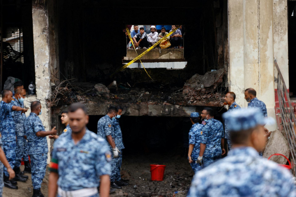 Príslušníci bangladéšskeho letectva pracujú na mieste po tom, čo cvičné lietadlo letectva zasiahlo areál školy. FOTO: Reuters