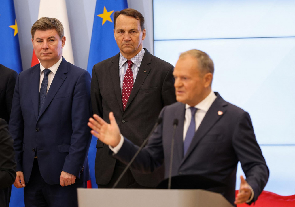 Poľský premiér Donald Tusk prehovoril počas tlačovej konferencie, na ktorej oznámil zmeny vo svojej vláde. Za ním stoja Jan Grabiec a poľský podpredseda vlády a minister zahraničných vecí Radoslaw Sikorski. FOTO: REUTERS