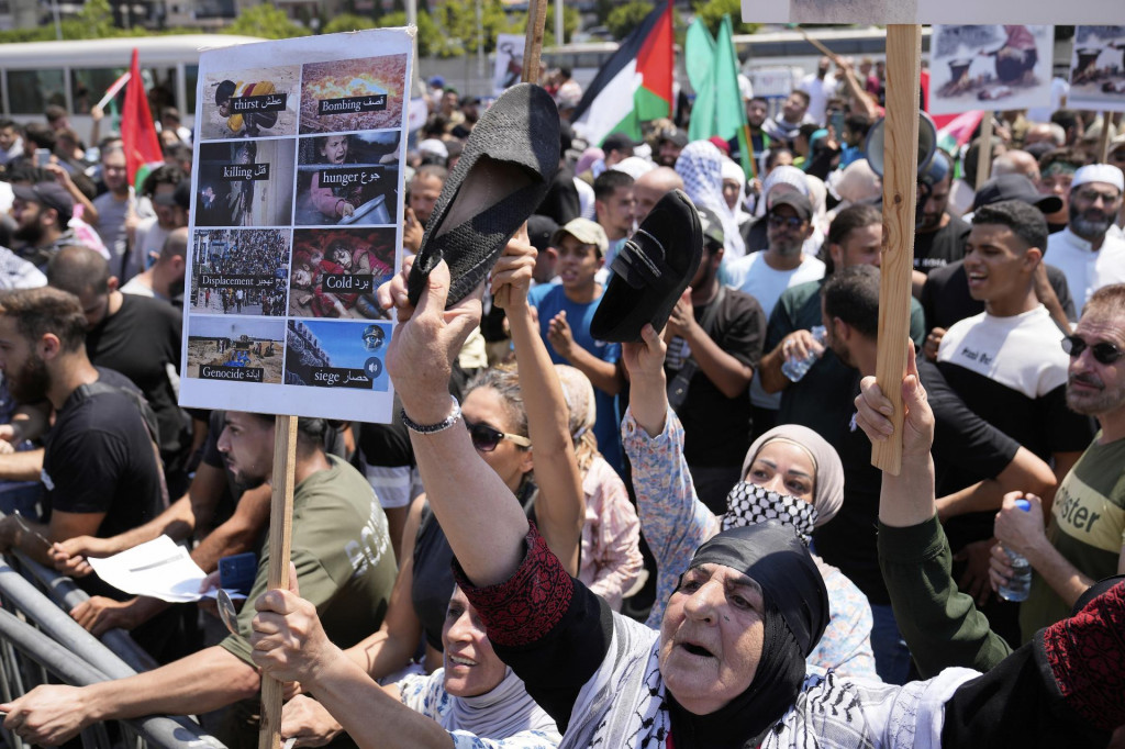 Demonštranti držia transparenty počas protestu proti vojenskému zásahu Izraela a hladovaniu civilistov v Pásme Gazy. FOTO: TASR/AP