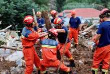 Hasiči odstraňujú trosky počas pátracej a záchrannej operácie po bleskových povodniach spôsobených silnými dažďami v dedine Shiwuz. FOTO: Reuters
