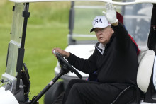 Americký prezident Donald Trump máva z golfového vozíka v golfovom stredisku, ktoré patrí jeho realitnej spoločnosti v škótskom Turnberry. FOTO: TASR/AP