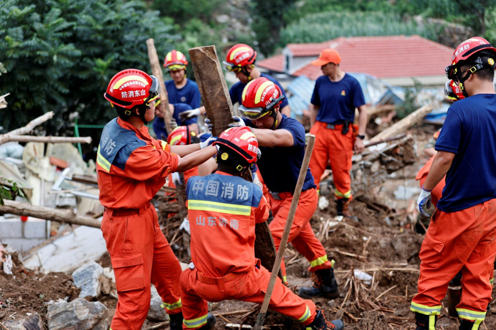 Hasiči odstraňujú trosky počas pátracej a záchrannej operácie po bleskových povodniach spôsobených silnými dažďami v dedine Shiwuz. FOTO: Reuters