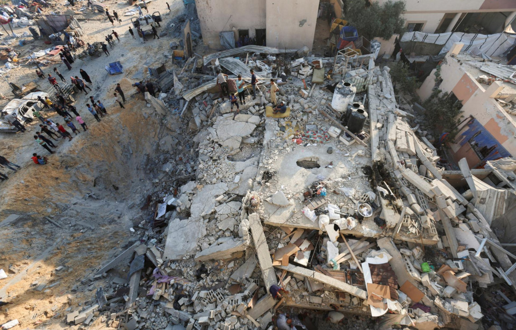Palestínčania sa zhromažďujú na mieste nočného izraelského leteckého útoku na dom v Chán Júnis v južnom Pásme Gazy. FOTO: Reuters