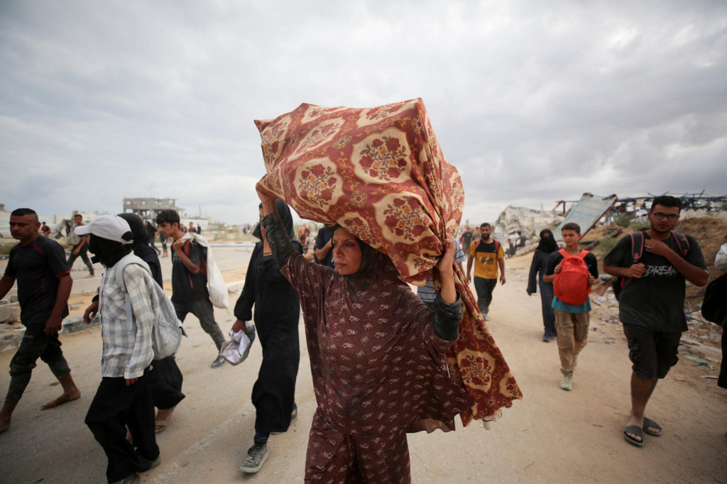 Palestínčania nesú zásoby pomoci, ktoré dostali od Humanitárnej nadácie pre Gazu v centrálnom Pásme Gazy. FOTO: Reuters