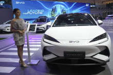 Na archívnej snímke z 23. júla 2025 modelka pózuje vedľa elektrického vozidla Sealion 7 čínskeho výrobcu BYD počas medzinárodného autosalónu Gaikindo v indonézskom meste Tangerang. FOTO: TASR/AP