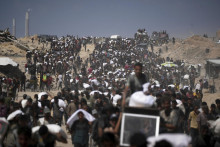 Palestínčania nesú vrecia s múkou z konvoja s humanitárnou pomocou na ceste do mesta Gaza na predmestí Bejt Lahíja na severe pásma Gazy v piatok 1. augusta 2025. FOTO: TASR/AP