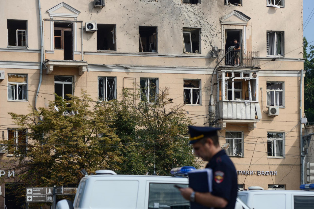 Policajt stojí pred poškodeným bytovým domom po útoku ukrajinského dronu v meste Voronež v Rusku. FOTO: Reuters