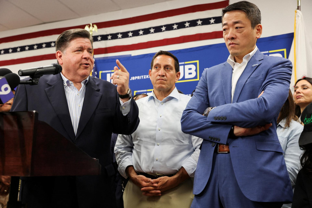 Guvernér štátu Illinois J.B. Pritzker hovorí v blízkosti zástupcov štátu Texas Genea Wu a Treya Martineza. FOTO: Reuters