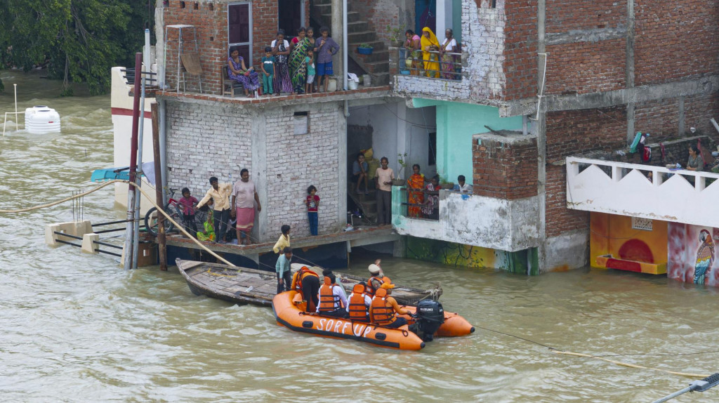 Na snímke príslušníci záchranných zložiek pomáhajú v zaplavenej oblasti v meste Prajágrádž v Indii 5. augusta 2025. FOTO: TASR/AP