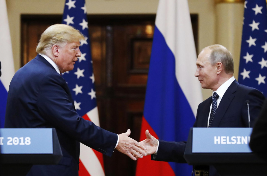 Na archívnej snímke z 16. júla 2018 americký prezident Donald Trump (vľavo) a ruský prezident Vladimir Putin si podávajú ruky na konci spoločnej tlačovej konferencie v Helsinkách. FOTO: TASR/AP
