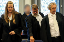 Na archívnej snímke z 30. júla 2025 v nemeckom Wuppertali obžalovaný Daniel S. (druhý zľava) stojí pred začiatkom pojednávania za svojimi advokátmi Adrianou Drewesovou (vľavo), Jochenom Ohligerom a Marcom Francoiseom (vpravo). FOTO: TASR/DPA