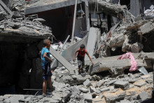 Palestínski chlapci si obzerajú miesto izraelského útoku na dom v meste Gaza. FOTO: Reuters