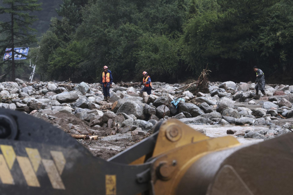 Príslušníci záchranných služieb prichádzajú na miesto po silných dažďoch v meste Chongqing v Číne. FOTO: TASR/AP